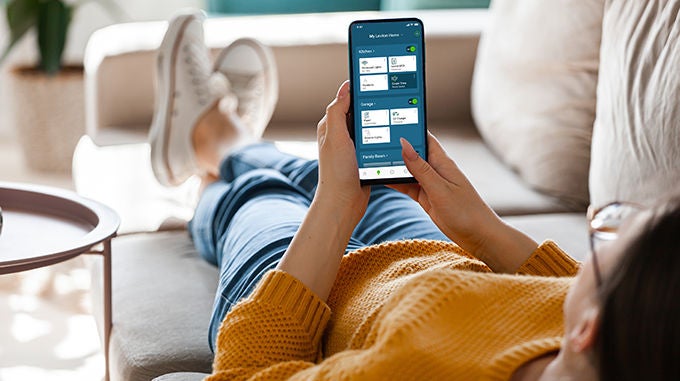 1310107376 Un hombre sostiene un iPhone con la aplicación My Leviton