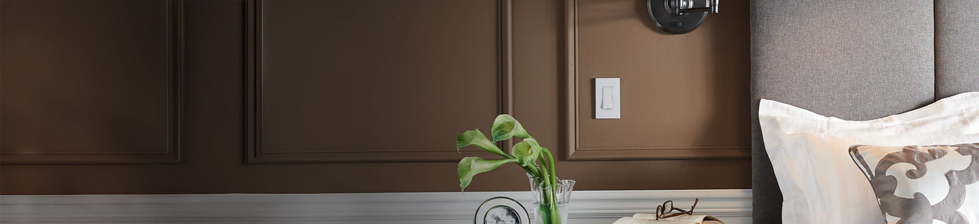 dormitorio marrón con pared que exhibe el atenuador deslizante Decora de Leviton